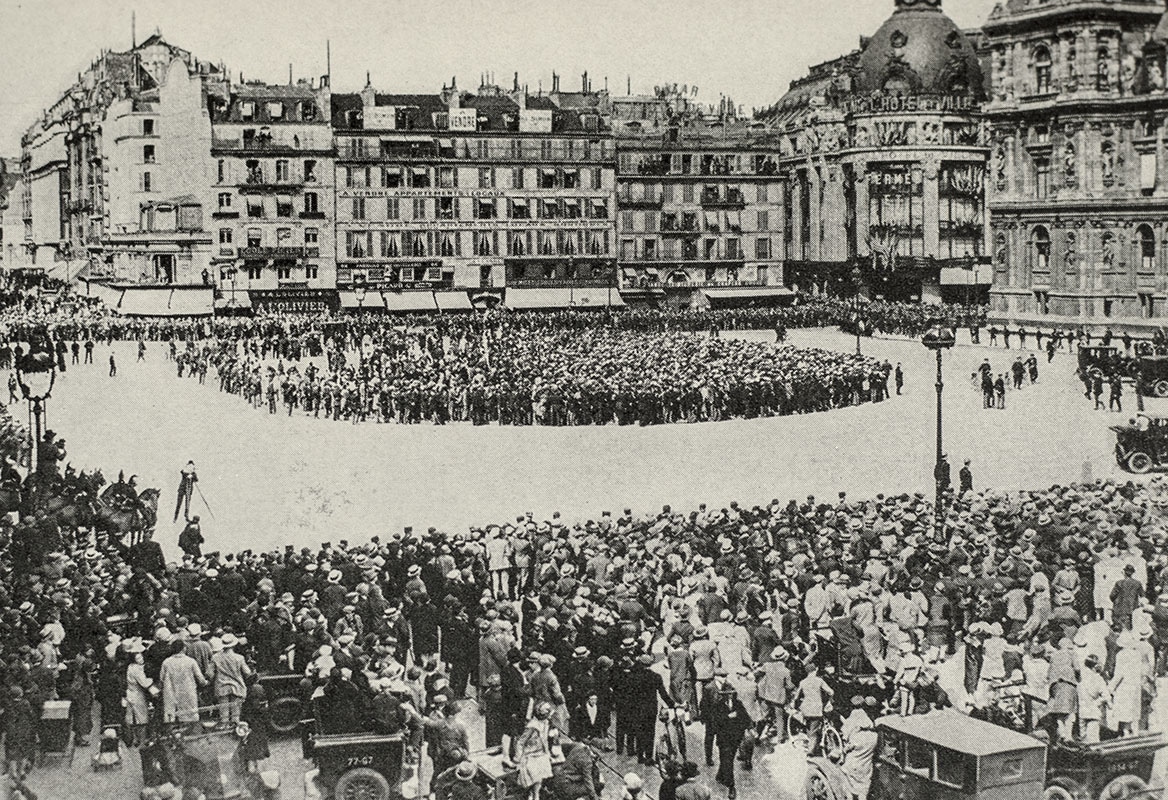 Historic black-and-white photo of a large crowd gathered in a city square