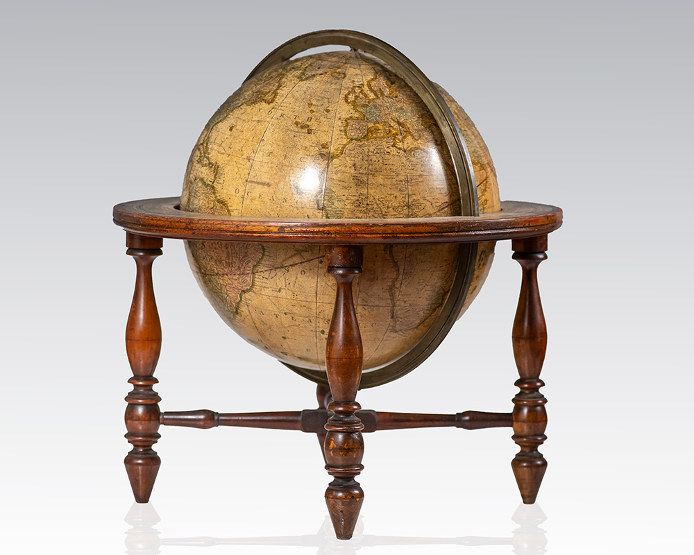 Antique terrestrial globe mounted on a wooden stand with four turned legs.