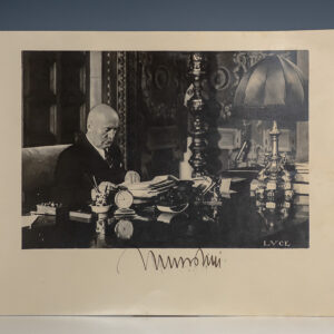 Photograph of a Man Sitting at an Ornate Desk